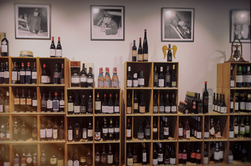 Unterschiedliche Weinflaschen in Regalen an der Wand des Lokals